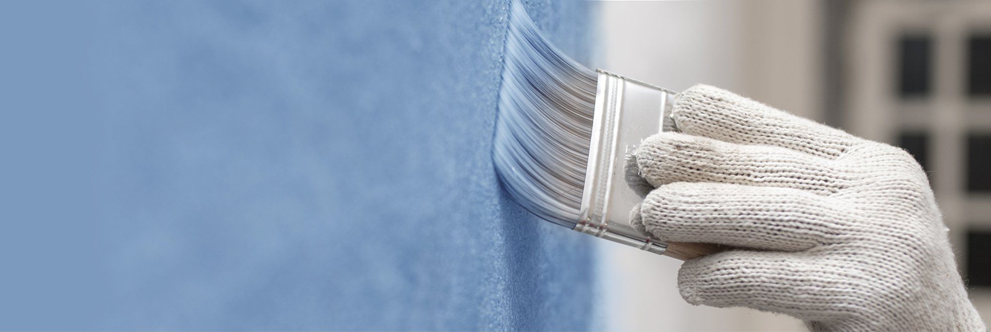 Ein Pinsel färbt die Wand blau